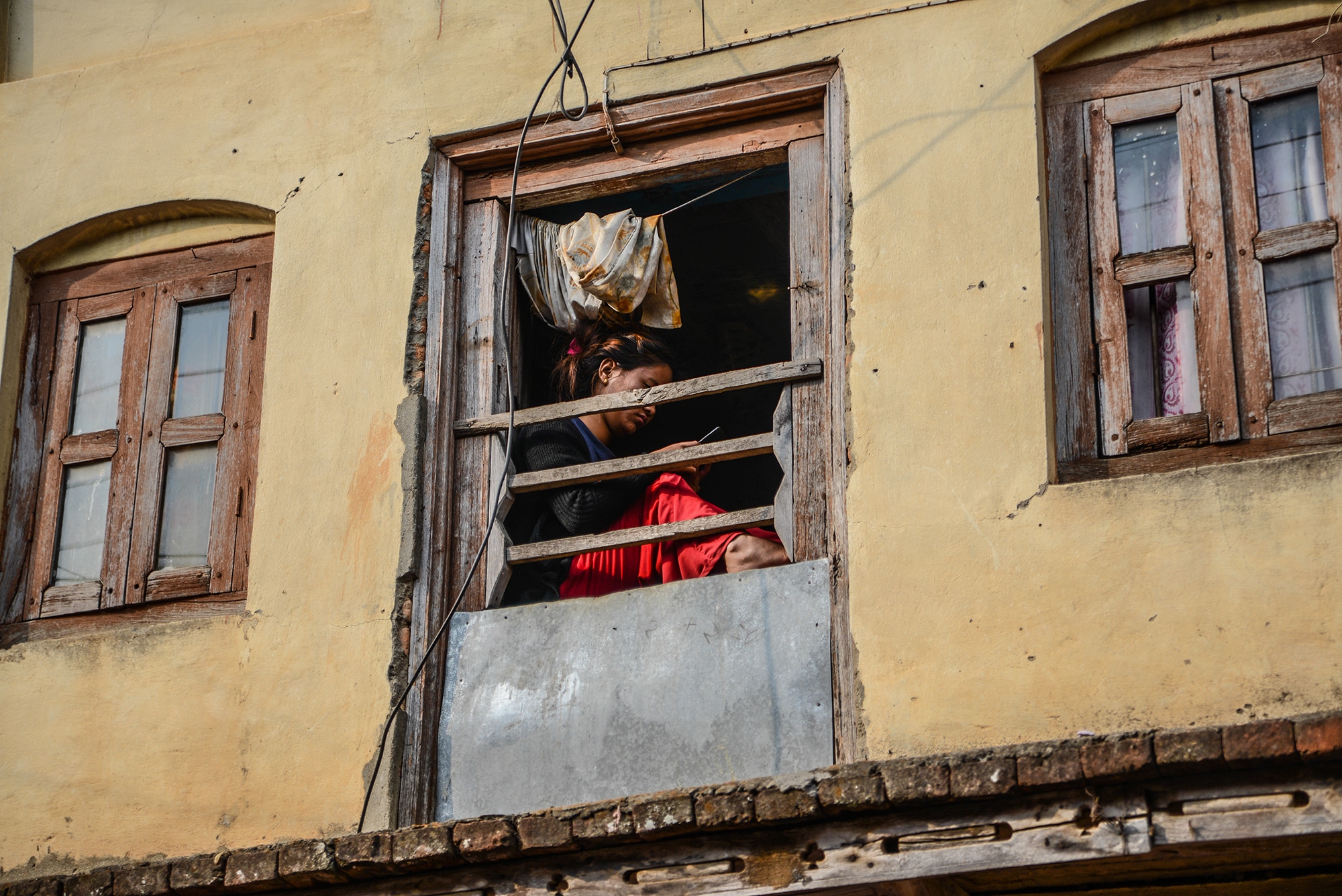 Une fille à la fenêtre à Bandipur au Népal
