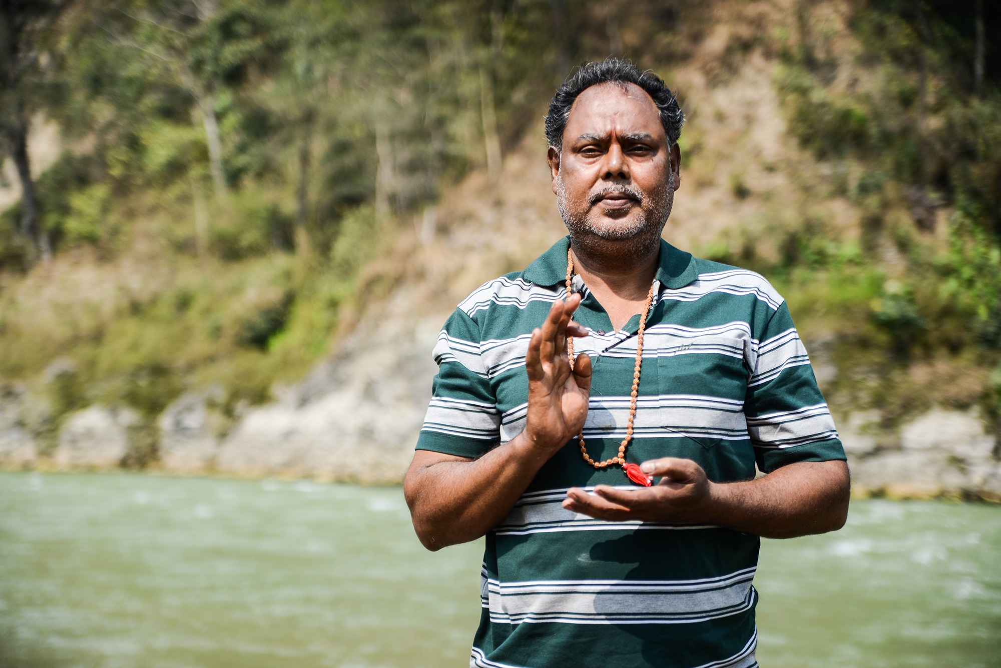 Un indien pose près d'une rivière au Népal