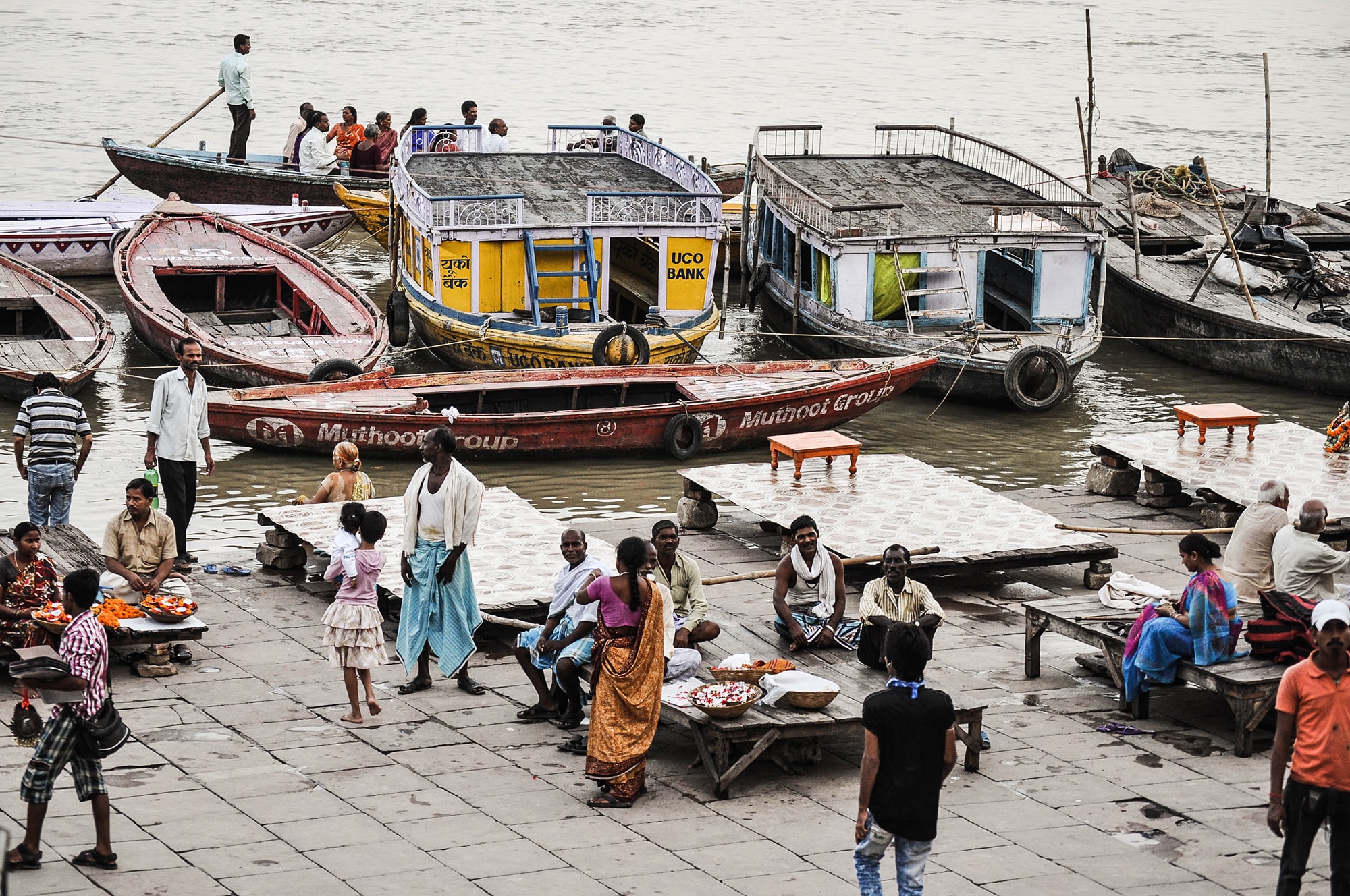 Des hommes et des barques au bord du ganges à Varanasi en Inde